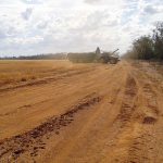 the tractor offloads harvested wheat into the header bin